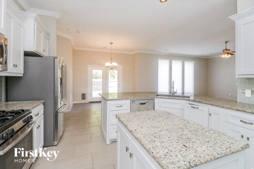 a large kitchen with white cabinets and granite counter tops