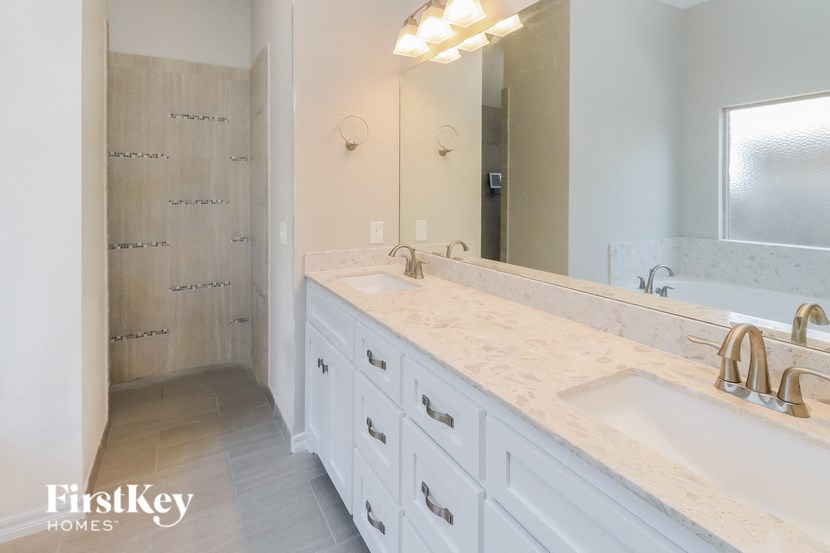 a white bathroom with two sinks and a shower