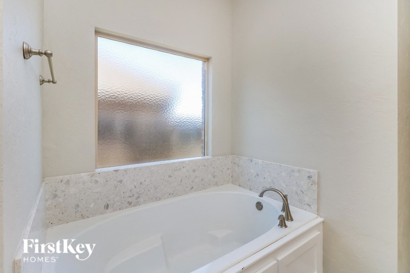 a small bathroom with a bath tub and a window