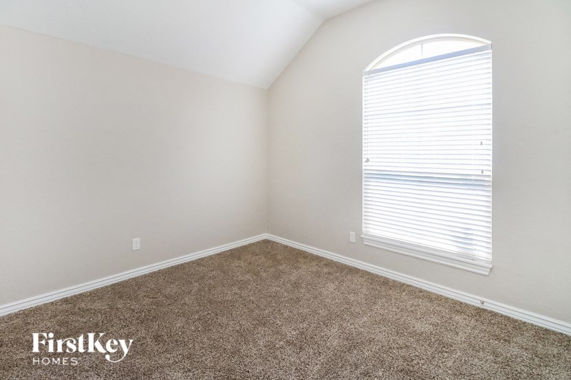 a bedroom with a large window and a carpeted floor