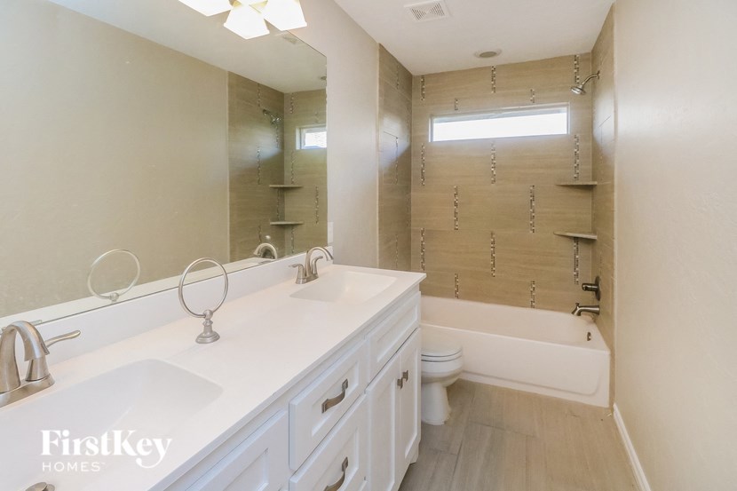 a bathroom with two sinks and a tub and a toilet