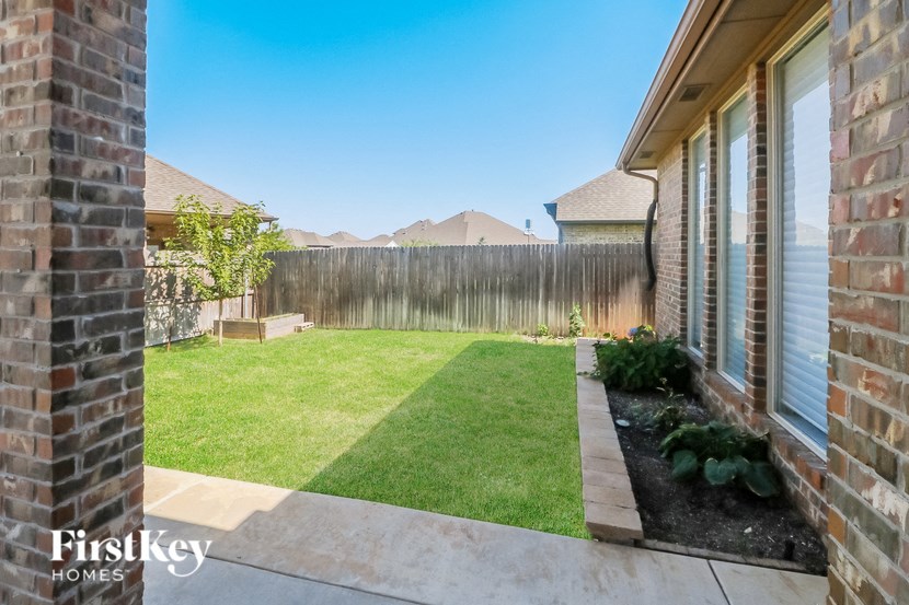 a backyard with a grass lawn and a fence