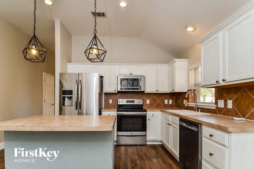 A kitchen with a FirstKey Homes sign on the island.
