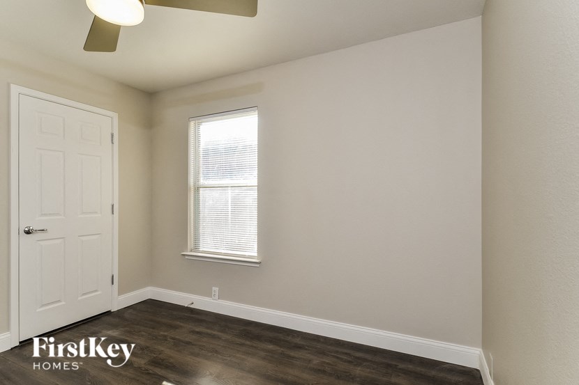 A room with a white door and a window with blinds.