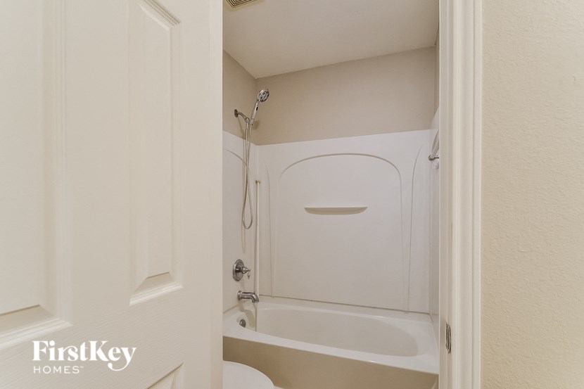 A white bathroom with a tub and a shower.