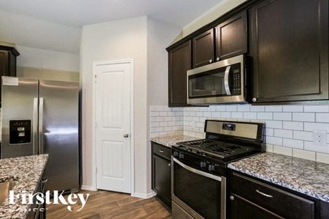 a kitchen with black cabinets and stainless steel appliances and granite counter tops
