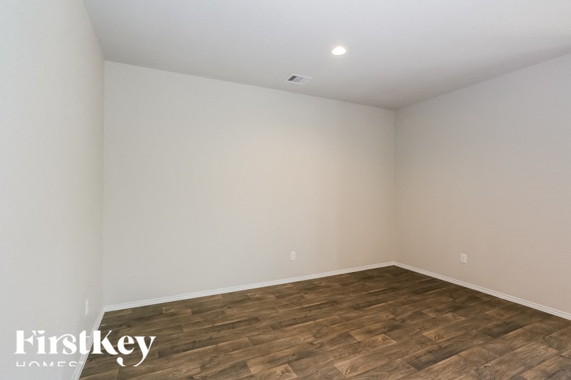an empty room with wood flooring and white walls