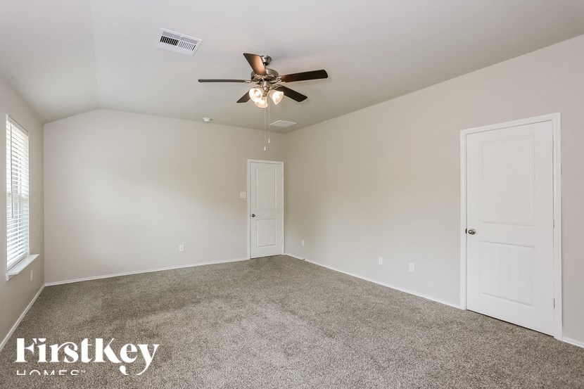 a bedroom with carpet and a ceiling fan