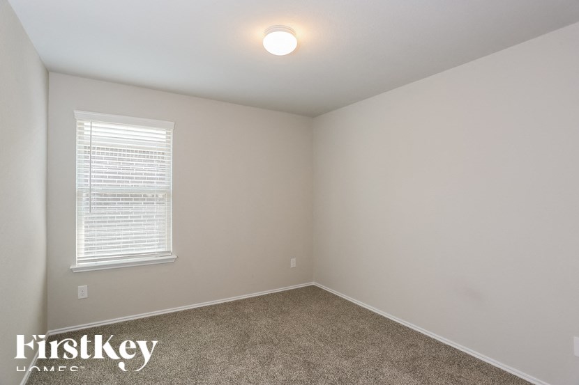 a bedroom with a carpeted floor and a window