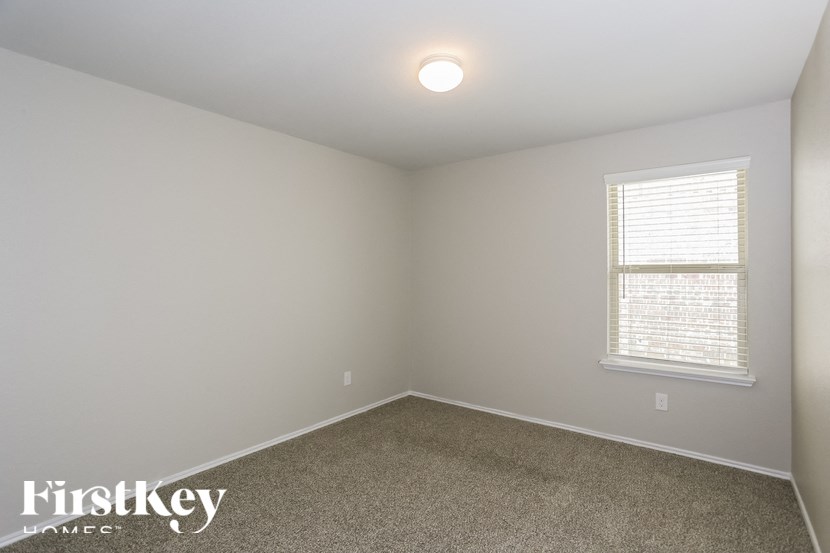 the bedroom of a home with a carpeted floor and a window
