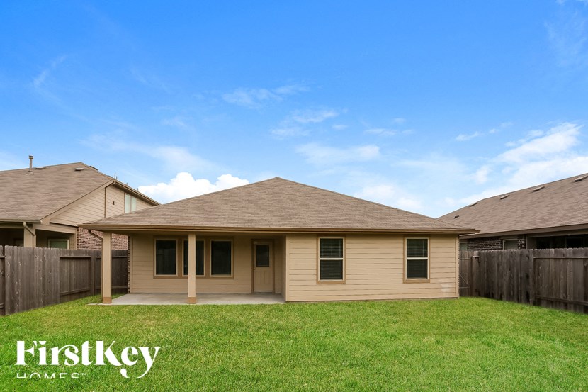 a small brown house with a yard and a fence