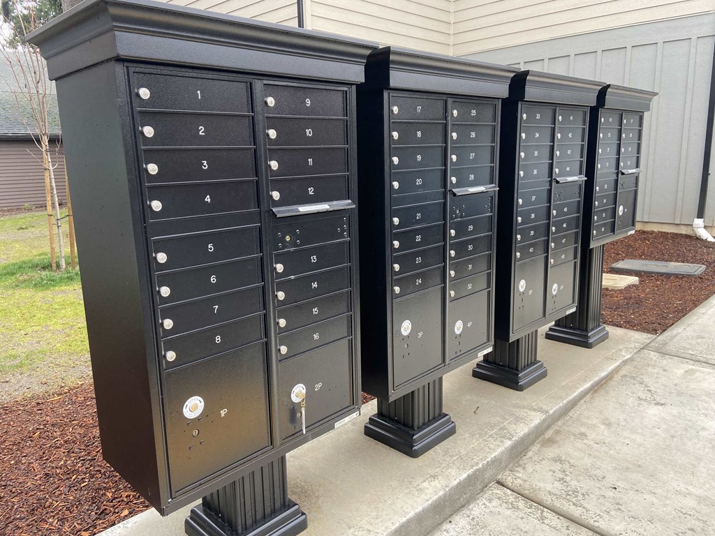 a group of mailboxes on pedestals on a sidewalk