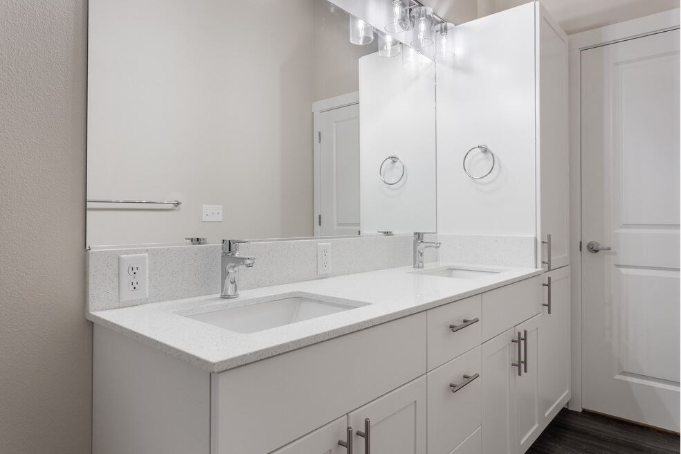 a bathroom with two sinks and a mirror