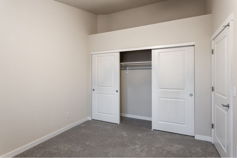 a bedroom with two closets and two doors