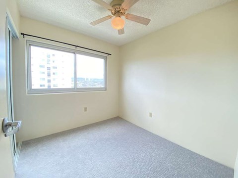 a bedroom with a ceiling fan and a window