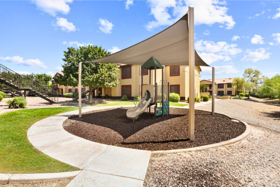 a playground with a slide in front of a building