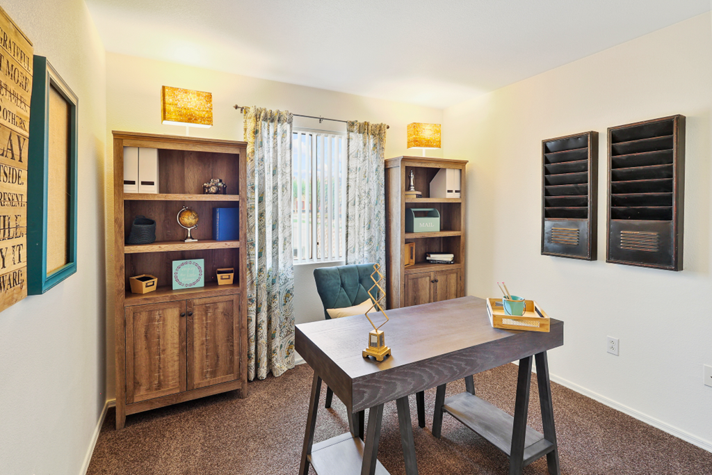 a home office with a wooden desk and a window