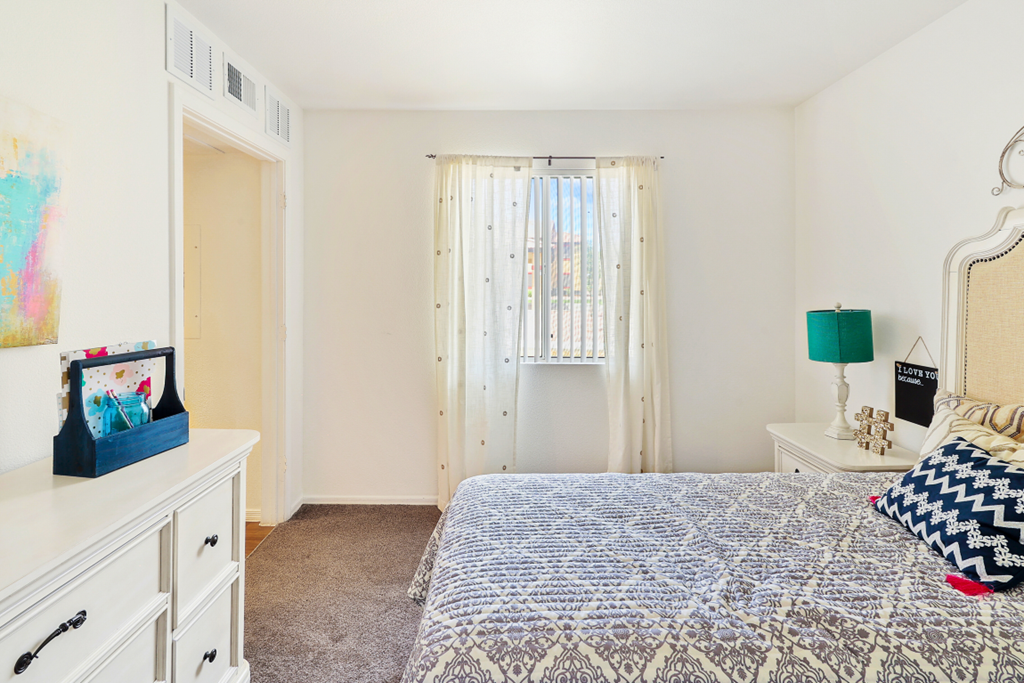 a bedroom with a bed and a closet and a window