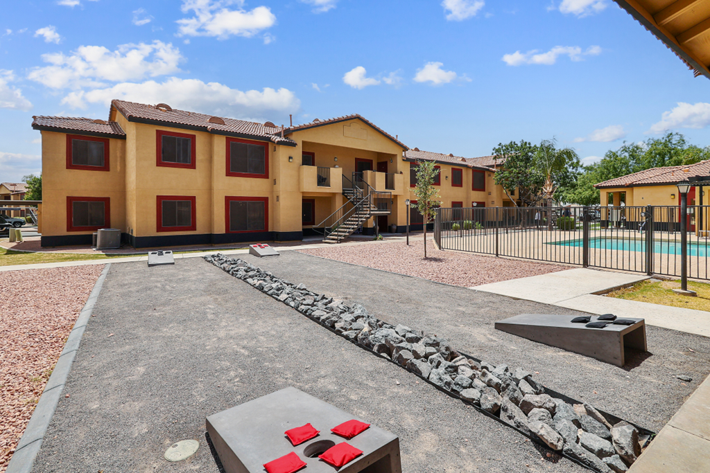 a courtyard with a pool and apartments in the background