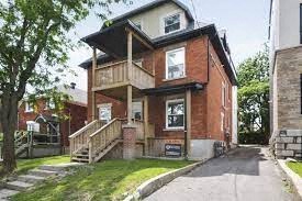 a brick house with a porch and a sidewalk