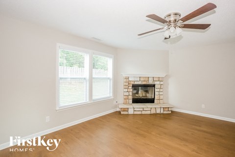 a living room with a fireplace and a ceiling fan