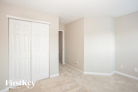 a bedroom with two closets and a carpeted floor
