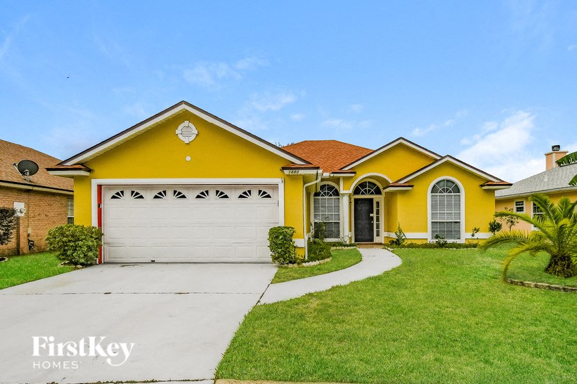 a yellow house with a driveway and a garage door