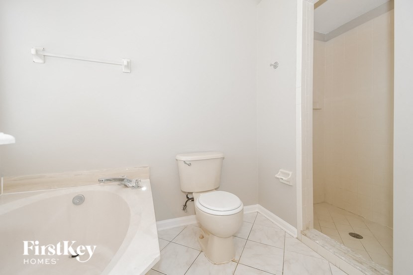 a bathroom with a toilet and a tub and a shower