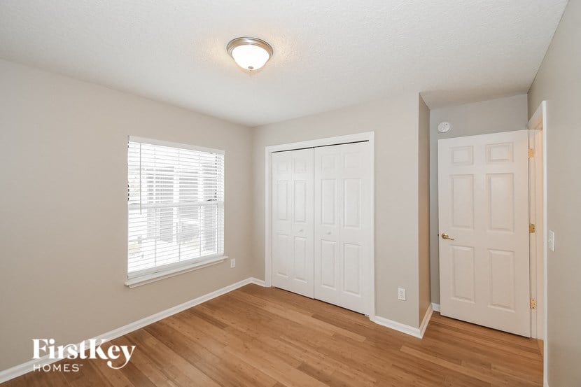 the living room of a home with a hardwood floor and white doors