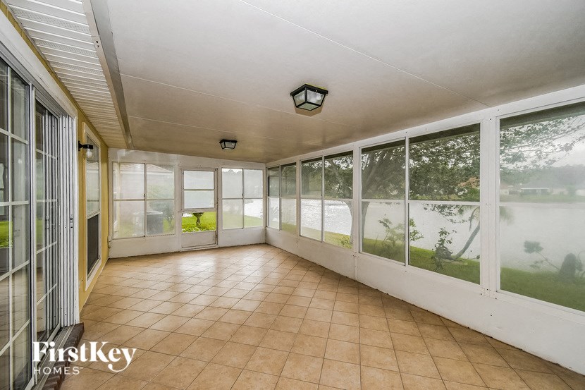 a conservatory with large windows and a tiled floor and