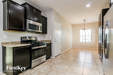 A kitchen with black cabinets and a granite countertop.
