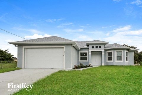a white house with a lawn and a garage