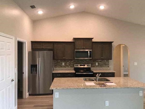 A kitchen with a granite countertop and stainless steel appliances.