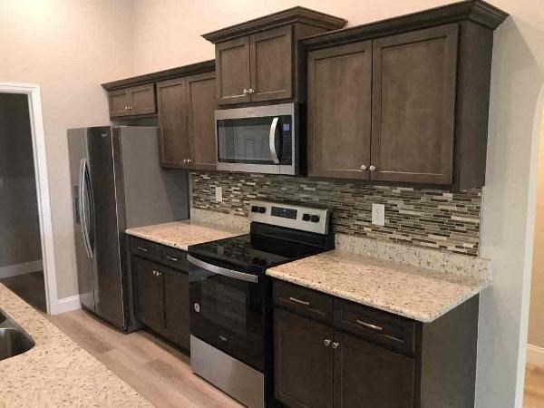 A kitchen with brown cabinets and a granite counter.