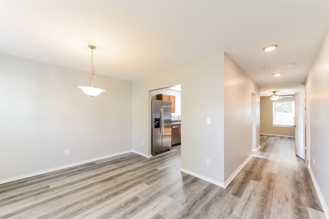 the living room and kitchen of a new home with a hardwood floor