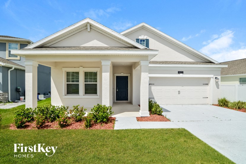 A white house with a black door and a window is shown.