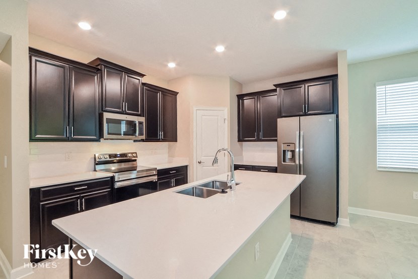 A kitchen with a white counter top and black cabinets.