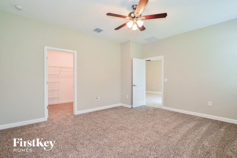 A room with a ceiling fan and carpeted floor.