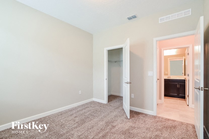 A room with a carpeted floor and a doorway leading to another room.