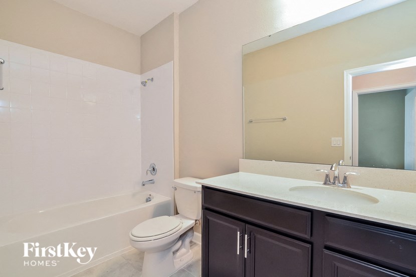 A bathroom with a white toilet, a white sink, and a white bathtub.