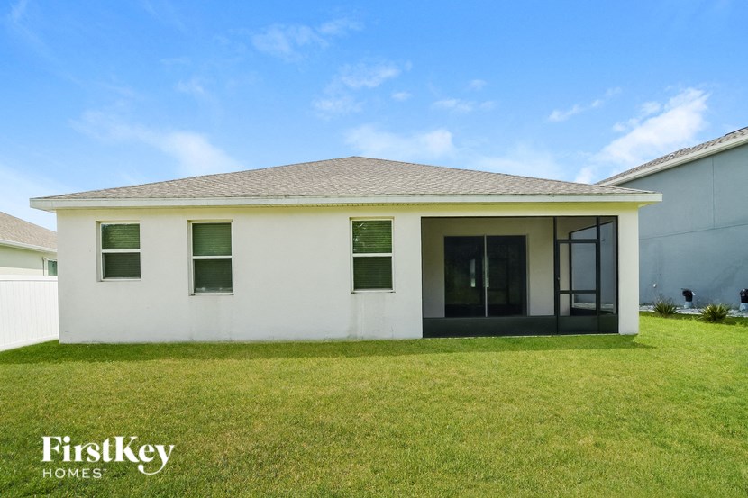 A white house with a black door and windows is for sale.