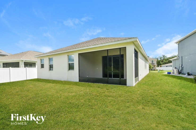 A white house with a brown roof and a glass door is for sale by FirstKey Homes.