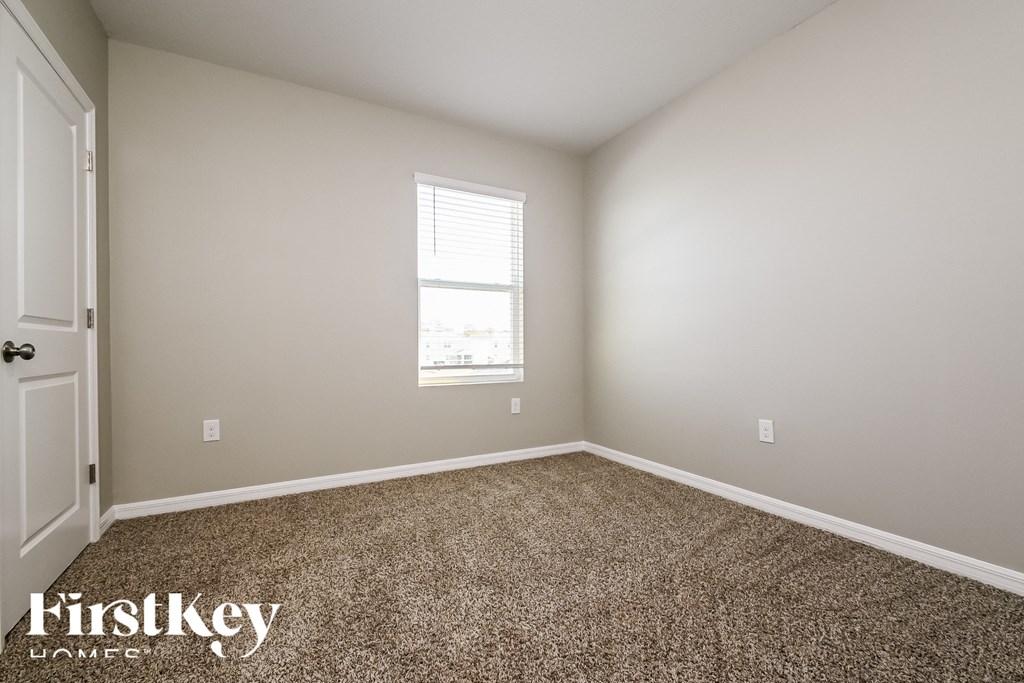 a empty room with carpet and a window