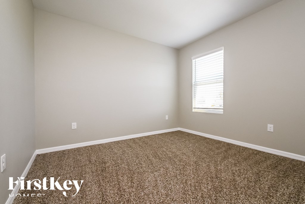 a empty room with carpet and a window