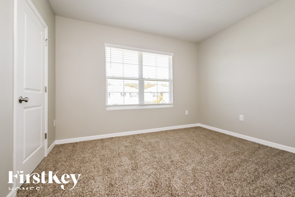 a empty room with carpet and a window