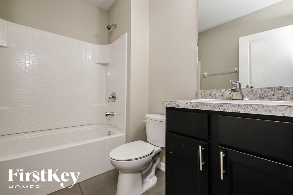 a bathroom with a toilet and a tub and a sink