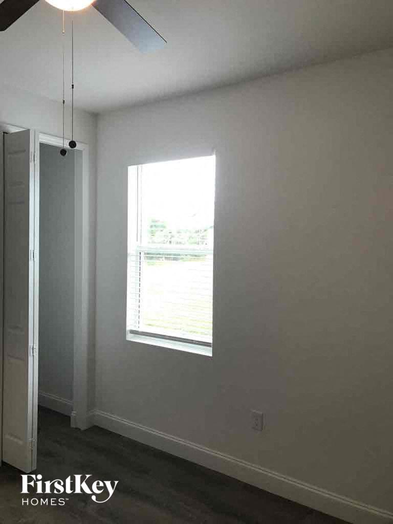 an empty room with a window and a ceiling fan