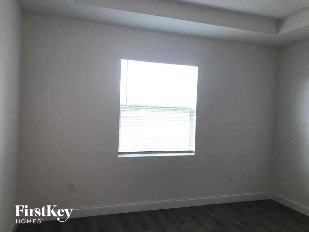 a window in a room with white walls and wooden floors