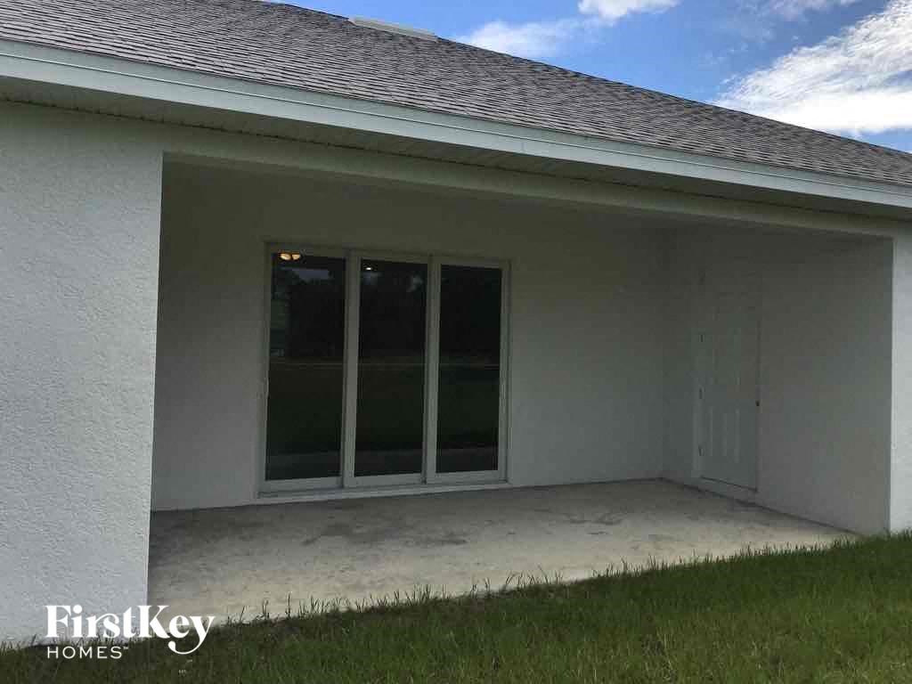 a patio in front of a house with grass