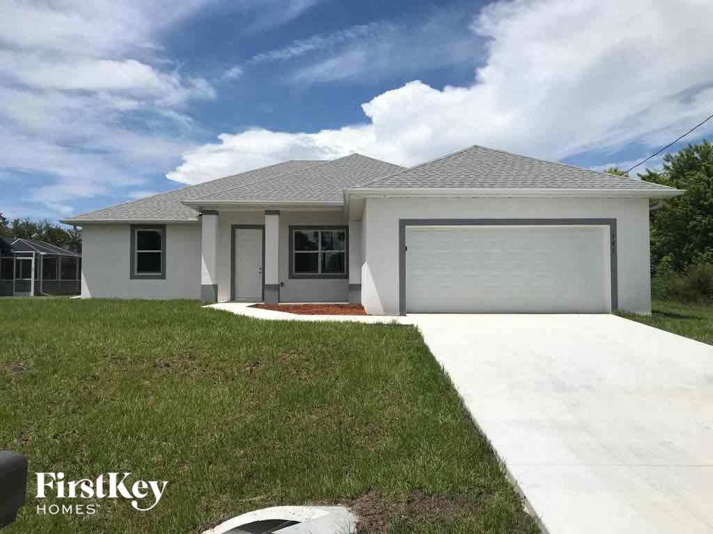 a white house with a lawn and a garage door